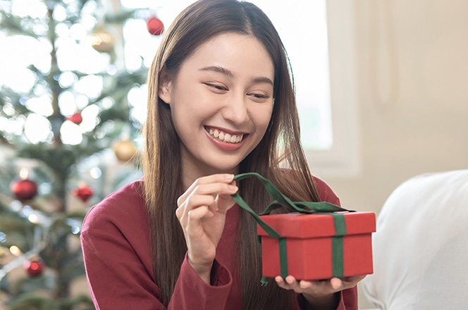 プレゼントを開けようとしている若い女性